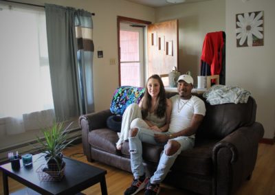 Couple sits on couch in living room at the Red House