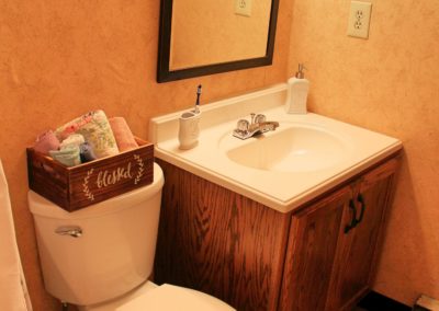 Bathroom in General Grant apartment showing edge of bathtub, a toilet, and vanity